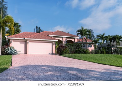 Typical Southwest Florida Pink Concrete Block And Stucco Home In The Countryside With Palm Trees, Tropical Plants And Flowers, Grass Lawn And Pine Trees. Florida. South Florida Single Family House