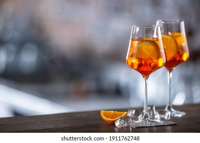 Typical summer sekt drink aperol spritz served in wine glass with aperol, prosecco, soda and a slice of orange.