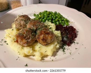 Typical Swedish köttbullar (meatballs) with peas, mashed potato and jam. Closeup of traditional homemade Scandinavian kottbullar on mashed potato with lingonberry jam is the Sweden 's national dish