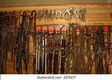 A typical tack room with bridles, bits and other horse tack