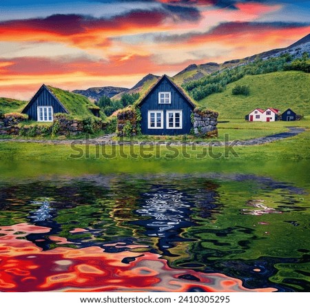 Typical turf-top houses reflected in the calm waters of small pond. Great sunrise in icelandic countryside. Gorgeous summer view of Skogar village, south Iceland. Traveling concept background.