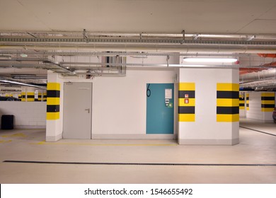 Typical Underground Car Parking Garage In A Modern Apartment House. Interior Pillars Painted Yellow.