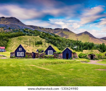 Typical view of Icelandic turf-top houses. Colorful summer morning in the Skogar village, south Iceland, Europe. Artistic style post processed photo.