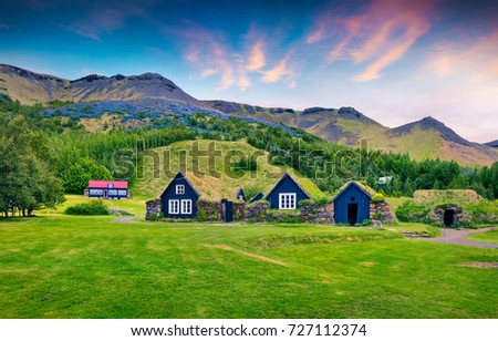 Typical view of Icelandic turf-top houses. Colorful summer sunrise in the Skogar village, south Iceland, Europe. Beauty of countryside concept background.
