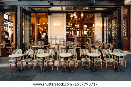Typical view of the Parisian street with tables of brasserie (cafe) in Paris, France. Architecture and landmarks of Paris. Cityscape of Paris