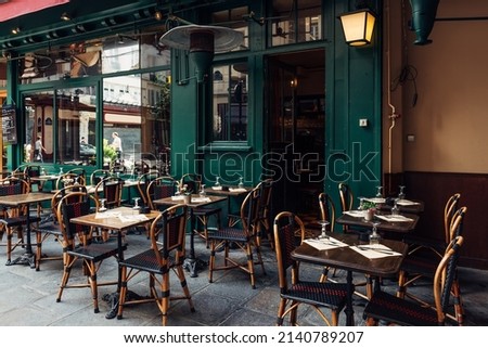 Typical view of the Parisian street with tables with tables of cafe in Paris, France. Architecture and landmark of Paris. Cozy Paris cityscape