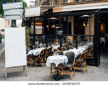 Typical view of the Parisian street with tables of brasserie (cafe) in Paris, France