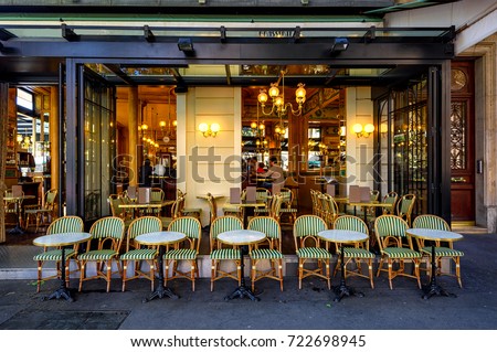 Typical view of the Parisian street with tables of brasserie (cafe) in Paris, France.  Architecture and landmark of Paris. Cozy Paris cityscape