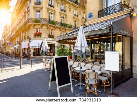 Typical view of the Parisian street with tables of brasserie (cafe) in Paris, France. Architecture and landmarks of Paris. Postcard of Paris