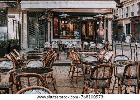 Typical view of the Parisian street with tables of brasserie (cafe) in Paris, France. Architecture and landmarks of Paris. Postcard of Paris