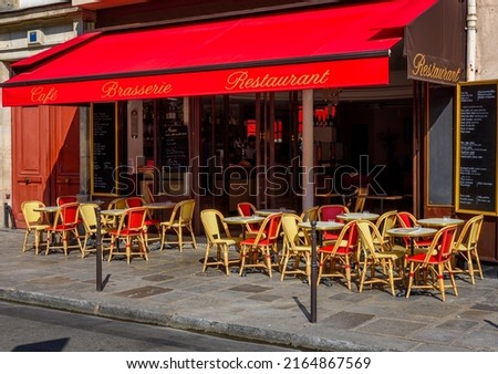 Typical view of street with tables of brasserie in Paris, France. Cozy cityscape of Paris. Architecture and landmarks of Paris.