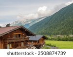 Typical wooden alpine houses on the mountain background in the Stubai or Stubaital valley, an alpine valley in Tyrol, Austria.