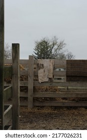 Typical Wooden Fence Down On The Farm With Dirty Towels And Laundry Air Drying From The Railing.