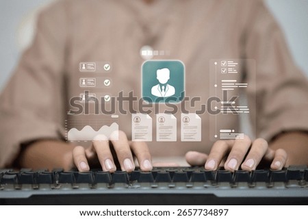 Typing on keyboard with digital interface for HR management, employee data, and profile review.