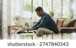 Typing, remote work and man with laptop in home for account manager, client portfolio and research. Admin, feedback and networking with person in living room for planning or thinking in house