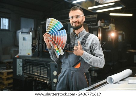 Typographer standing with color swatches at the printing manufacturing.