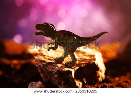 Tyrannosaurus rex silhouette in smoke. Creative burning scenery with a small miniature. End of the dinosaur age.