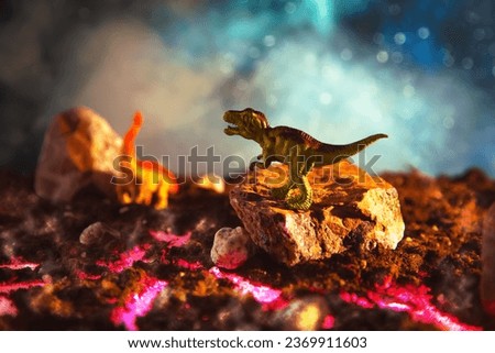 Tyrannosaurus rex silhouette in smoke. Creative burning scenery with a small miniature. End of the dinosaur age.