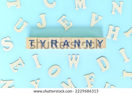 Tyranny government form concept. Wooden blocks typography flat lay in blue background.