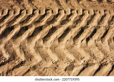 Tyre Mark Background. Tire Track Shape. Trail Lines On Dry Brown Sand Pattern. Road Construction Site Backdrop. Heavy Machinery Imprint. Dried Mud Vehicle Wheel Shape.