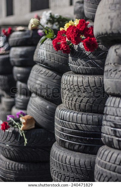 Tyres cars\
stacked in columns. The top is a memorial bread and flowers.\
Location Kiev, Maidan Nezalezhnosti.\
Close-up.