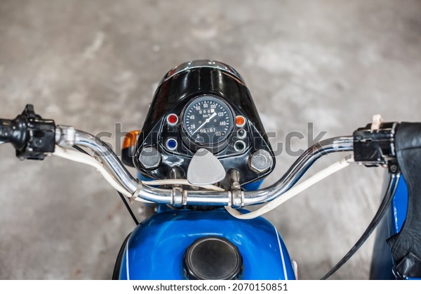 TYUMEN, RUSSIA- AUGUST 12,\
2021: Museum exhibit headlight with speedometer of an old blue URAL\
motorcycle