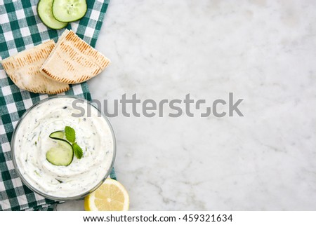 Tzatziki and pita bread on marble