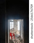 Tzfat, Israel - a destroyed, abandoned old Jewish house with windows overlooking the Galilean mountains. Trash. A red plastic chair inside the room.