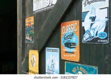 Tzum, The Netherlands - October 28 2021: Rusty And Weathered Retro Plates On An Old Door Of A Car Garage. Spark Plugs, Service And Repair, Renault And Route 66.  