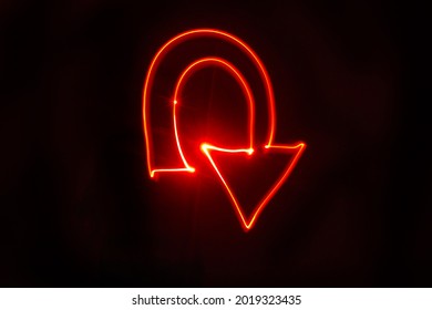 U turn arrow bright red light painting. Studio shot with a black background. Drawn with red LED lights. - Shutterstock ID 2019323435
