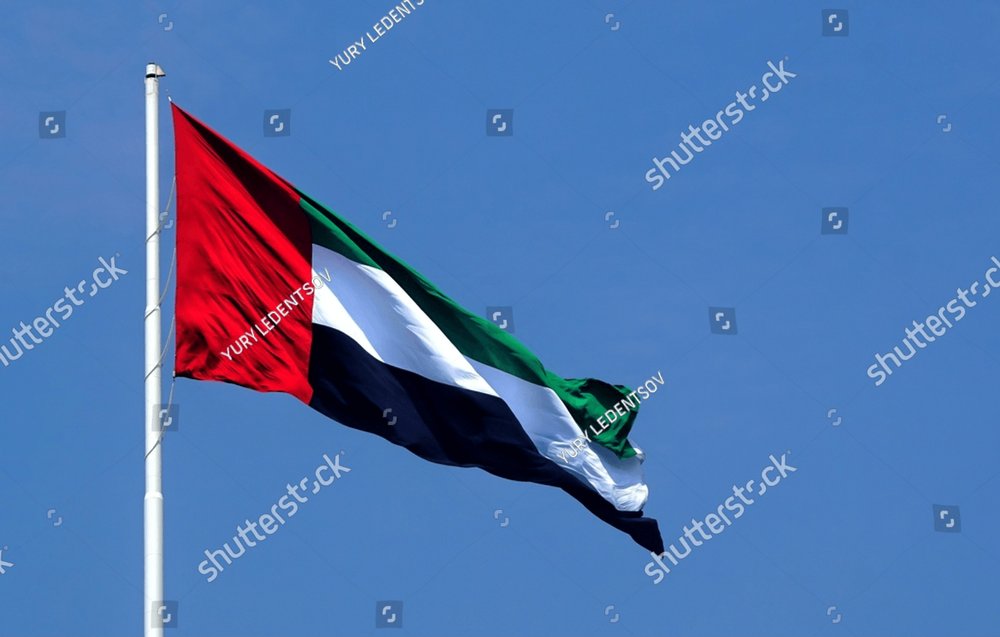 UAE flag waving in the blue bright sky, national symbol of UAE Holiday ...