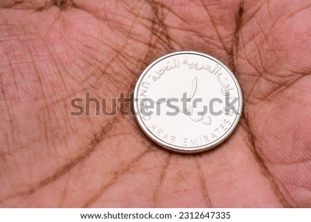 UAE One dirham coin placed on hand, best use for Donation or saving.