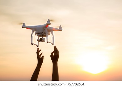 The UAV drone and photographer man hands. drone copter flying with digital camera. UAV Drone with digital camera. Flying camera take a photo and video. The drone with camera takes pictures of the sky.