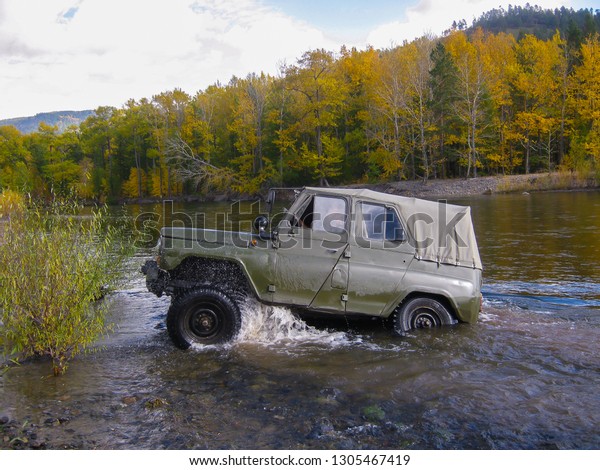 UAZ car stuck in the\
river