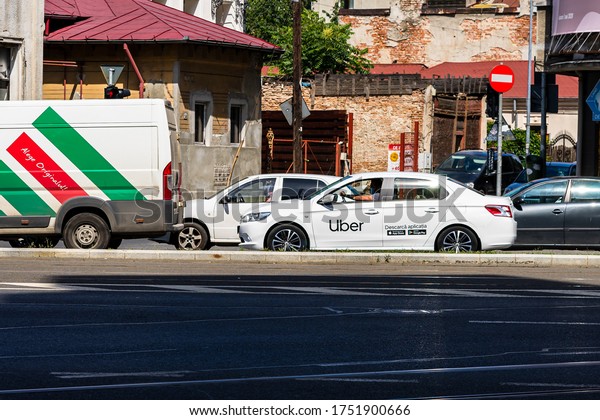 Uber car in traffic at rush hour. Car pollution,\
traffic jam in the morning and evening in the capital city of\
Bucharest, Romania, 2020