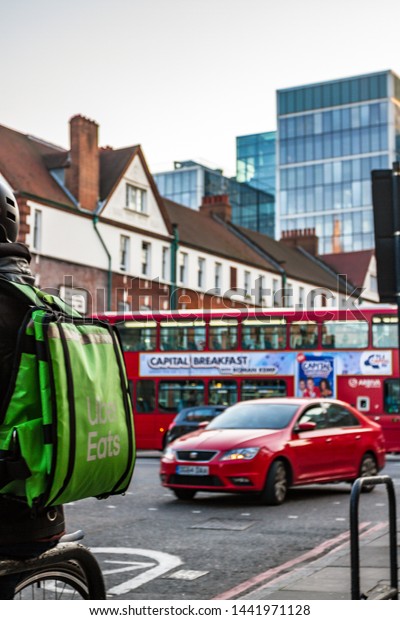 Uber Eats Rider\
Delivers Food at Lunch Time in the East End Curry Hot Spot District\
in London,UK-April 2019