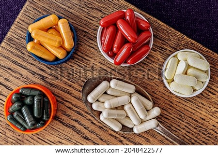 ubiquinol (coQ10) coenzyme q10, chlorophyll, n-acetyl cysteine (NAC), l-lipoic acid and b-complex supplements on wooden board.  immune prevention care concept