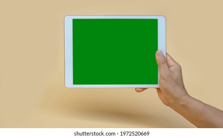 Ubon Ratchathani, Thailand - May 4, 2021: Man Hand Holding Apple IPad, Green Screen, Copy Space, Space For Text, On Yellow Isolated Background.