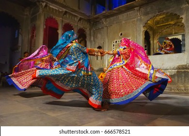 Udaipur, India  - JANUARY 29, 2014: An unidentified young indian women in national costumes, in veils,  perform dance at a traditional theatre exposing local Rajasthan culture in Udaipur, India. 