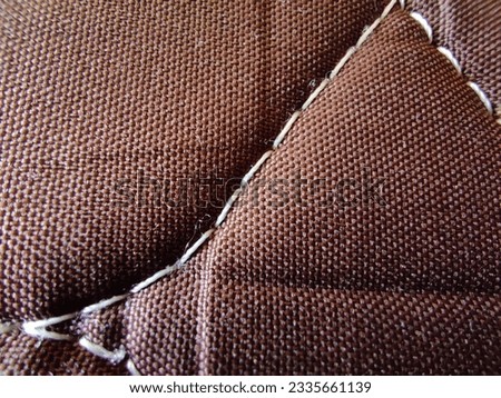 Udaipur, India - May 12 2021: A close-up photo of the stitch texture of a cloth used for a mattress, showing the intricate pattern of weaved threads and the natural texture of the fabric