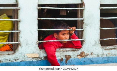 Udaipur, Rajasthan, India; 17th February 2015:  A Boy Leaning Out Of A Train Window In India With A Sad And Thoughtful Gaze