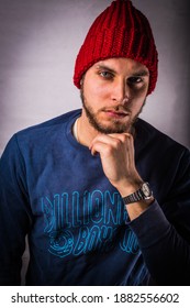 Udine, Friuli Venezia-Giulia, Italy, 24th January 2018: Caucasian Model With Amazing Blue Eyes Dressed With A Billionaire Boys Club Sweater And A Red Cap Poses In A Studio With Isolated Background