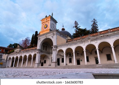 Udine, Italia - 12 06 2019: Low view of center town landmark "Loggia of St. Giovanni" in 
Liberty square with Udine's castle behind, outdoor sunset time, cloudy sky