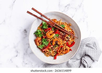 udon noodles, shrimp with vegetables and fresh herbs, in a bowl with chopsticks, light background, homemade, no people, - Powered by Shutterstock - Get 15% off with code: PIKWIZARD15