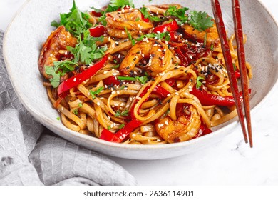 udon noodles, shrimp with vegetables and fresh herbs, in a bowl with chopsticks, light background, homemade, no people, - Powered by Shutterstock - Get 15% off with code: PIKWIZARD15