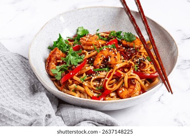 udon noodles, shrimp with vegetables and fresh herbs, in a bowl with chopsticks, light background, homemade, no people, - Powered by Shutterstock - Get 15% off with code: PIKWIZARD15