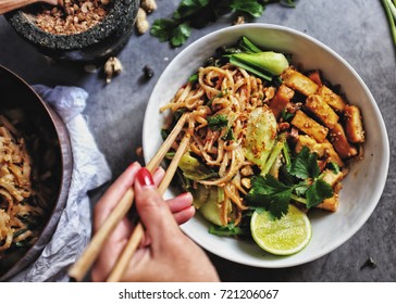  Udon with Padthai sauce, Healthy Vegetarian/vegan menu; Padthai noodle with smoke tofu and mixed vegetable - chinese baby Bok Choy , garlic chive, shallot and crushed peanut topping. chopstick hold.