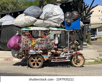 Udon Thani, Thailand - November 27, 2019: Street scene in Udon Thani with overloaded parked tuk-tuk vehicle