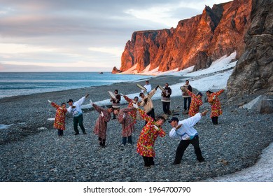 Uelen, Chukotka Peninsula, Russia - July 9, 2009. Musicians and dancers of the Chukchi-Eskimo folk ensemble Uelen on the seashore. People in traditional clothes near the rocky coast of the Chukchi Sea