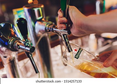 Ufa, Russia, 1 July, 2019: Heineken Bartender Poured Beer Into A Glass.